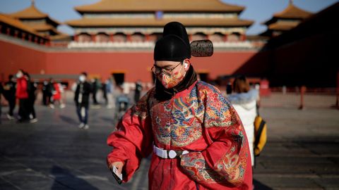 Un hombre vestido con ropas tradicionales chinas, en la Ciudad Prohibida de Pekín