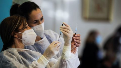 Dos sanitarias preparando la vacuna en un Portugal