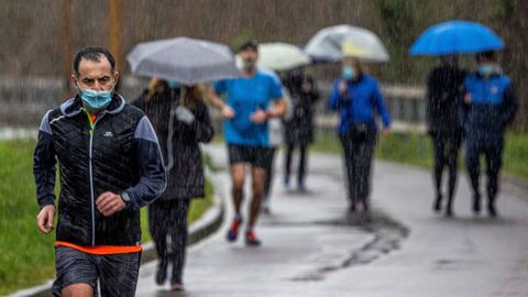Vecinos de Oviedo hacen deporte bajo la lluvia
