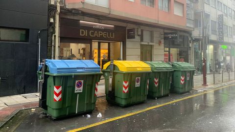 Contenedores de basura situados delante de un comercio de Pontevedra