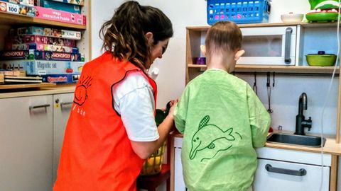 Un miembro de la Asociación Galbán jugando con un niño con cáncer