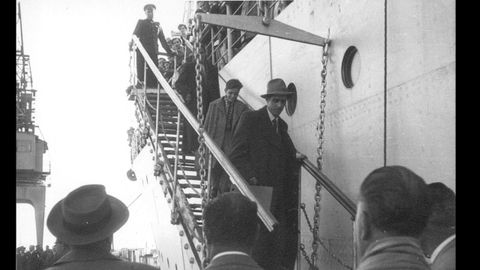 Retornados españoles exiliados en la URSS descienden al puerto de Castellón desde el barco ruso Crimea. En la parte superior de la escalera, un oficial soviético supervisa el desembarco