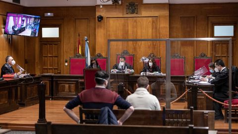 Imagen de un juicio el miércoles en la Audiencia Provincial de Ourense en la que se aprecia la separación con mamparas, la señal por vídeo y las fundas de plástico en los micros. La entrada a la sala no está permitida y los testigos lo hacen solo en el momento de declarar