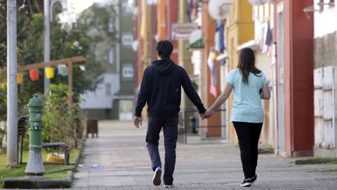 Una pareja camina por el barrio de Recimil