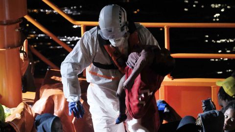 Un tripulante de la Salvamar Macondo traslada a la pequeña al muelle
