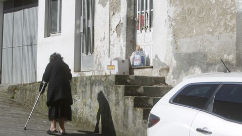María José caminando por delante de su casa, con la compra en la puerta
