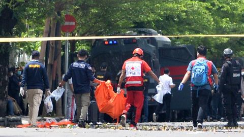 Agentes de policía retiran un cadáver de la catedral del Sagrado Corazón de Makassar tras el atentado islamista