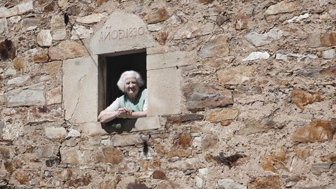 Dina Rodríguez, hija del último pastor protestante que hubo en Besullo, asomada a una
ventana de su domicilio, Casa Xuacón, que albergó la capilla evangélica