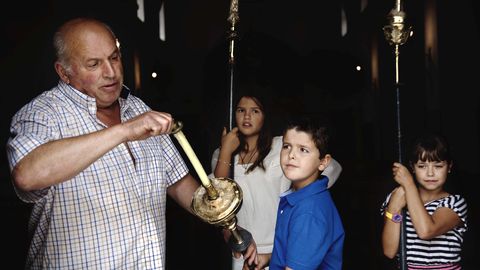 Lixandro Piñeiro con los niños Rosalía del Chano, Jaime de Manuela y María de Cachoupo,
preparando la salida de la procesión de Las Veigas. Carolina del Chano saluda a Etelvina de
Pontones, una de las mujeres que carga con la imagen de la Virgen de las Veigas