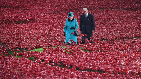 La reina Isabel II y el príncipe Felipe caminando entre amapolas rojas plantadas en el foso de la Torre de Londres en memoria de los británicos y de la Commonwealth muertos en la Primera Guerra Mundial
