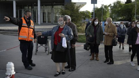 Vacunación masiva frente al covid en Expocoruña para personas de 75 a 79 años. Miembros de Protección Civil orientando en la entrada a los citados