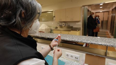 Vacunas como esta que preparan en el Hospital da Mariña están siendo administradas a la población de la comarca que le toca, lo que contribuye a mitigar el impacto de la pandemia