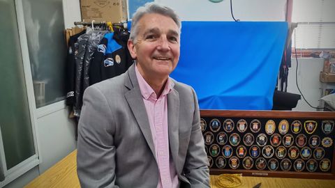Manuel Seijas, en su taller, en el bajo de su vivienda, rodeado de uniformes y escudos de las policías locales con las que trabaja