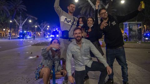 Varios jóvenes reunidos y en ambiente festivo, en una calle de Barcelona