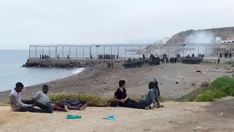 Un grupo de inmigrantes marroquí observa el despliegue del Ejército de Tierra