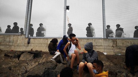Miembros de la policía Nacional vigilan la verja que separa Ceuta de la localidad marroquí de Fnideq