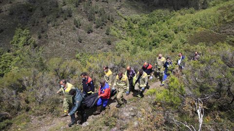 Bomberos forestales, miembros de Protección Civil y Guardia Civil trasladan el cuerpo del desaparecido en la aldea de Ventosa