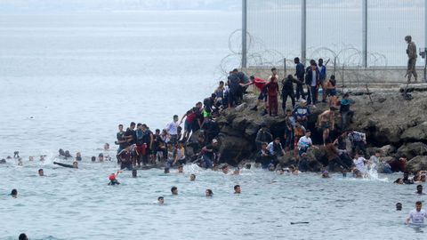 Ciudadanos marroquíes agolpados en uno de los espigones fronterizos de Ceuta