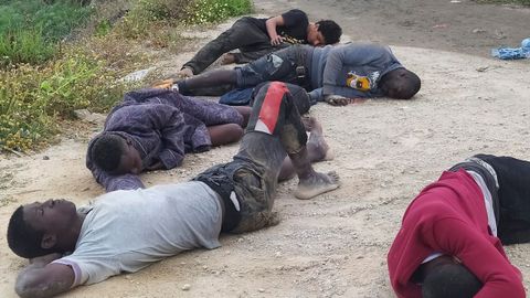 Un grupo de inmigrantes descansa tras cruzar la frontera