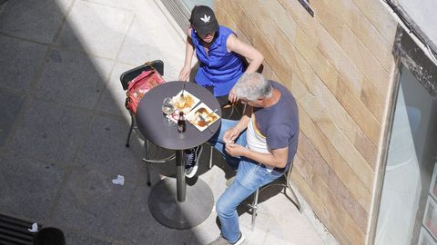 Un hombre y una mujer, en la terraza de un bar en Castro Urdiales