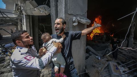 Un palestino pide ayuda después de que su casa fuera alcanzada por un ataque aéreo israelí en Gaza