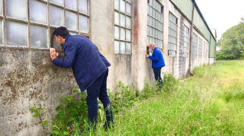 El portavoz del PP, Javier Castiñeira, y el alcalde de Begonte, mirando las naves de Manuel Mallo
