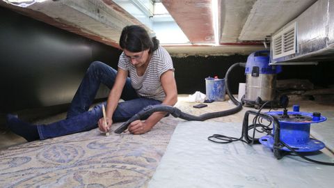 La restauradora Iria López limpia los restos de materiales que se sedimentan en los mosaicos romanos de Lugo