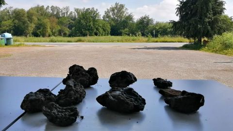 Al fondo de la imagen, el terreno donde se realizará un sondeo con georradar en busca de vestigios de la antigua iglesia de Cereixa y la aldea de Sobrado. En primer término, escorias de hierro halladas en la zona que pueden proceder del núcleo desaparecido