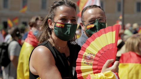 Una asistente a la marcha contra los indultos luce abanico con la bandera de España en Colón