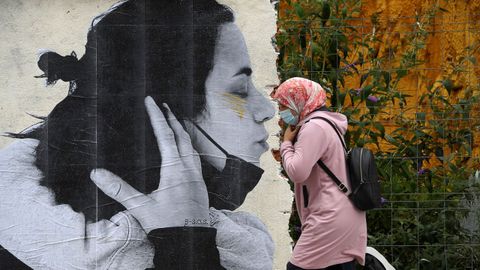Una persona pasa por delante de una de las obras del artista Sentydo ART de la campaa dedicada a los besos sin mascarillas en Oviedo