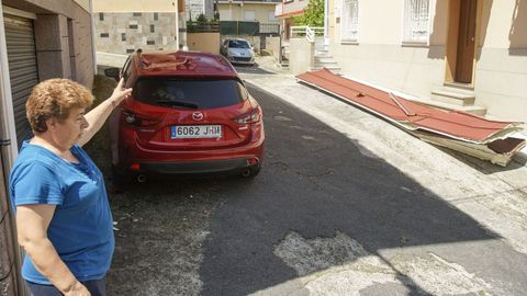 Manuela, vecina del barrio de la Cruz Alta, señala uno de los coches dañados por una chapa metálica que llegó volando por un callejón cercano