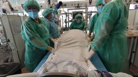 Personal de enfermería, realizando una maniobra para cambiar de posición a un paciente, en A Coruña