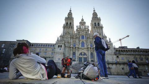 Varios peregrinos se fotografían en la plaza del Obradoiro.