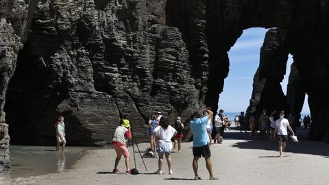 Varias personas fotografían los arcos de piedras de la playa de As Catedrais, en Ribadeo.