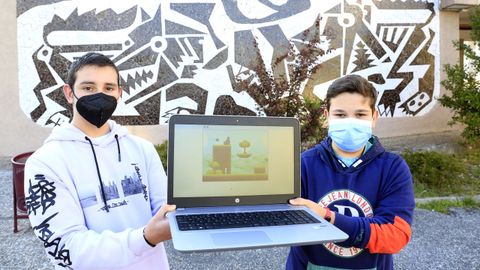 A la izquierda, Alberto Fernández, de 14 años, y Adrián Agruña, de 13, con una imagen de su videojuego
