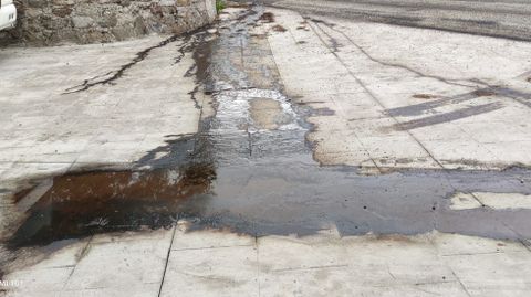 Uno de los charcos con alquitrán que dejaron las obras en Castro de Carballedo