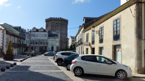 Coches aparcados en la plaza de Santa María, con la torre de los Andrade al fondo