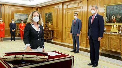 El rey Felipe VI y el presidente del Ejecutivo observan a la vicepresidenta primera y ministra de Asuntos Económicos y Transformación Digital, Nadia Calviño