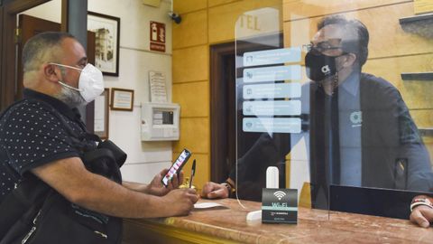 Un cliente en el servicio de recepción del hotel Suizo, en Ferrol, el jueves