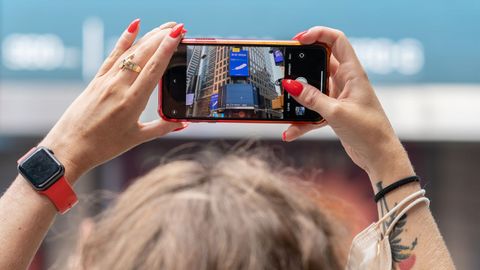 Una mujer sacando una fotografía durante el despegue en Times Square, Nueva York