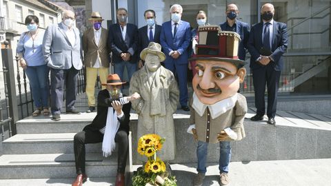 Los participantes en el homenaje a Laxeiro, con el ramo de girasoles en su honor y uno de los cabezudos inspirados en uno de sus cuadros.