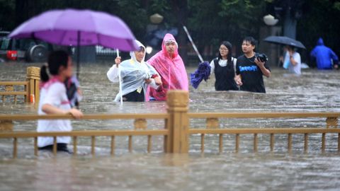 Personas caminando sobre la carretera inundada en la ciudad china de Zhengzhou