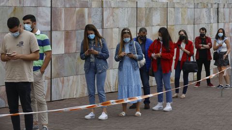 Los primeros veinteañeros citados el jueves en Santiago esperan su turno para la vacuna