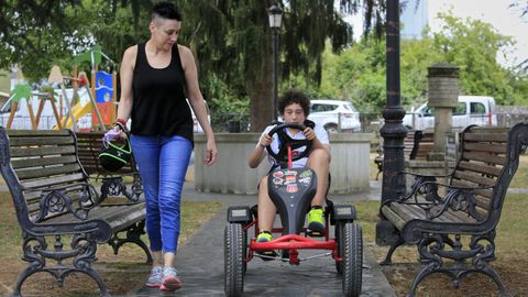 Ana López y su hijo Rodrigo, de 15 años, que usa un coche de cuatro ruedas para protegerse de sus caídas