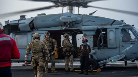 Marineros estadounidenses de la Unidad Móvil de Desactivación de Artefactos Explosivos a bordo de un helicóptero en la cubierta de vuelo del portaaviones USS Ronald Reagan (CVN 76) se preparan tras recibir una llamada de auxilio del Mercer Street