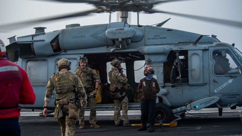 Marineros estadounidenses de la Unidad Mvil de Desactivacin de Artefactos Explosivos a bordo de un helicptero en la cubierta de vuelo del portaaviones USS Ronald Reagan (CVN 76) se preparan tras recibir una llamada de auxilio del Mercer Street