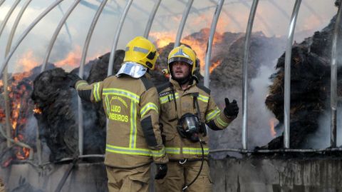 Dos de los bomberos que acudieron a Xullán, junto al fuego