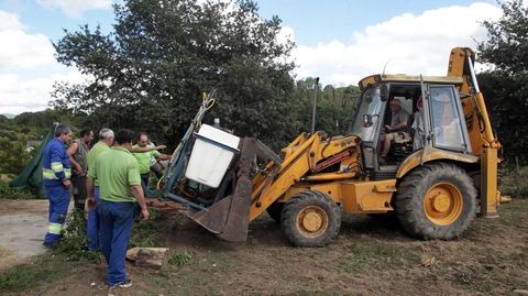 Unos vecinos retiran material agrícola que estaba cerca del almacén, para que no ardiese