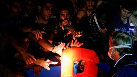 Personal del barco de rescate Sea Watch 3 reparte chalecos a migrantes rescatados en el Mediterráneo el pasado día 1