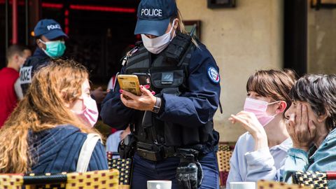 La policía francesa se asegura de que se cumplan los controles sanitarios en un bar de París